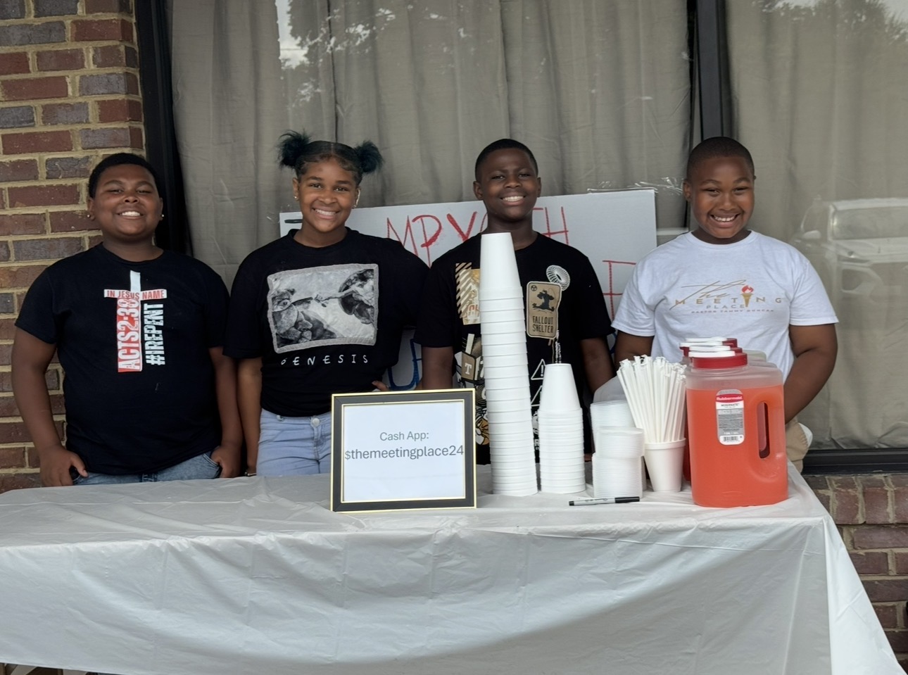 Young people serving drinks at a community outreach table